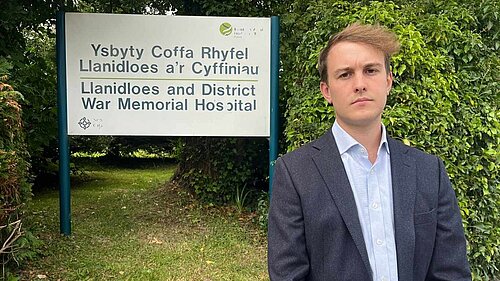 Cllr Glyn Preston in front of Llanidloes Hospital